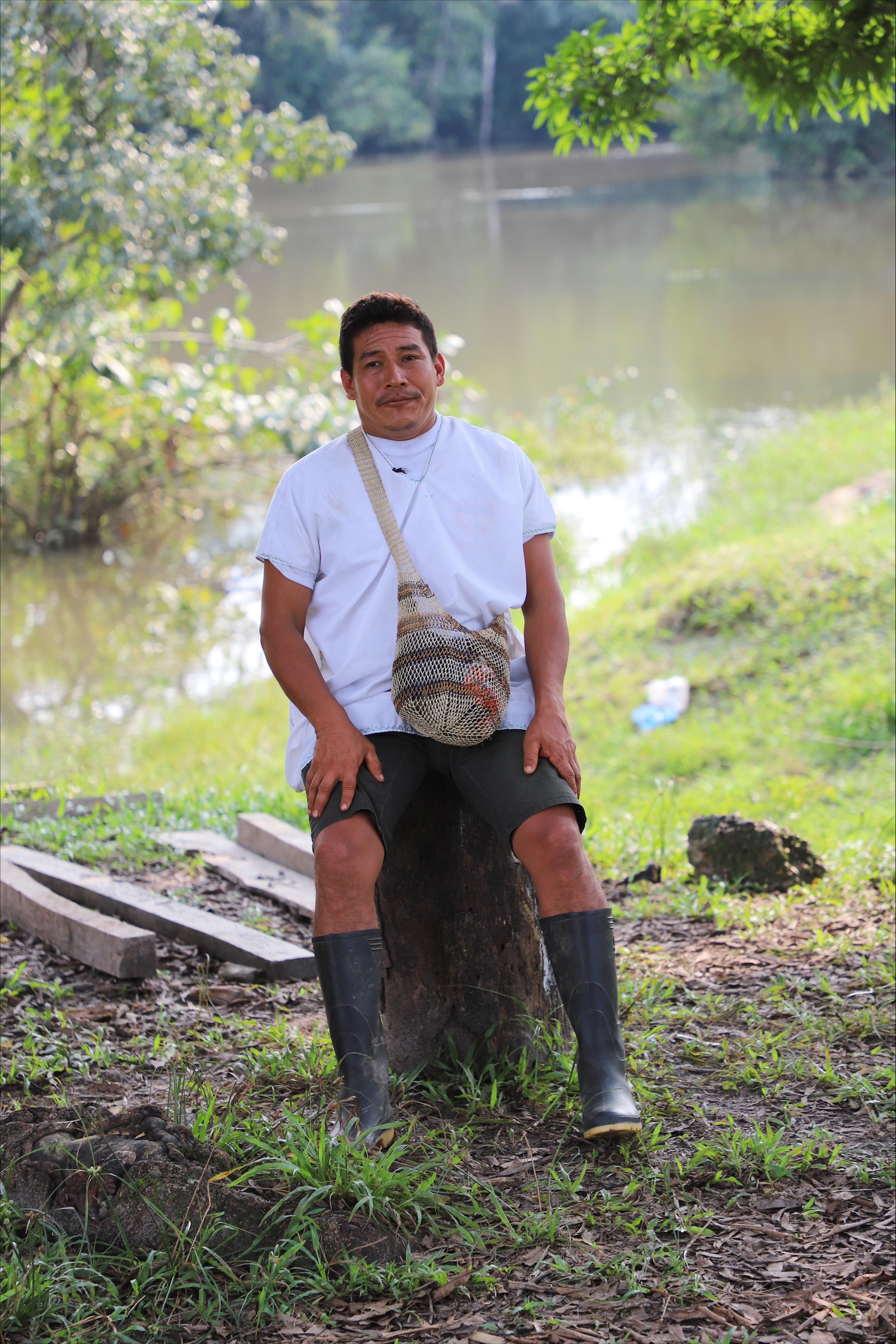 A man sits on a stree stump.