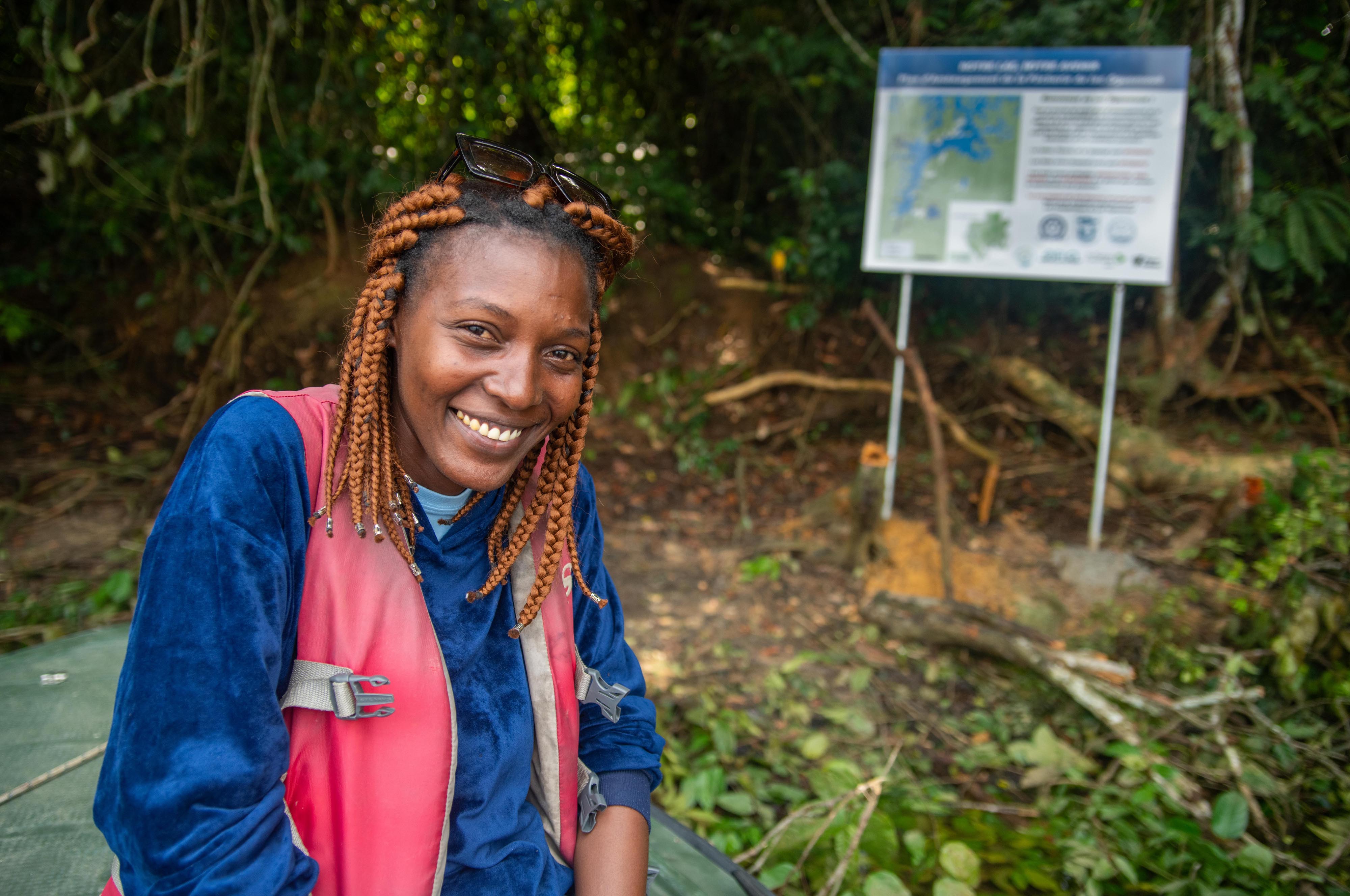 Rengouwa Maeva sits in a forest and smiles.