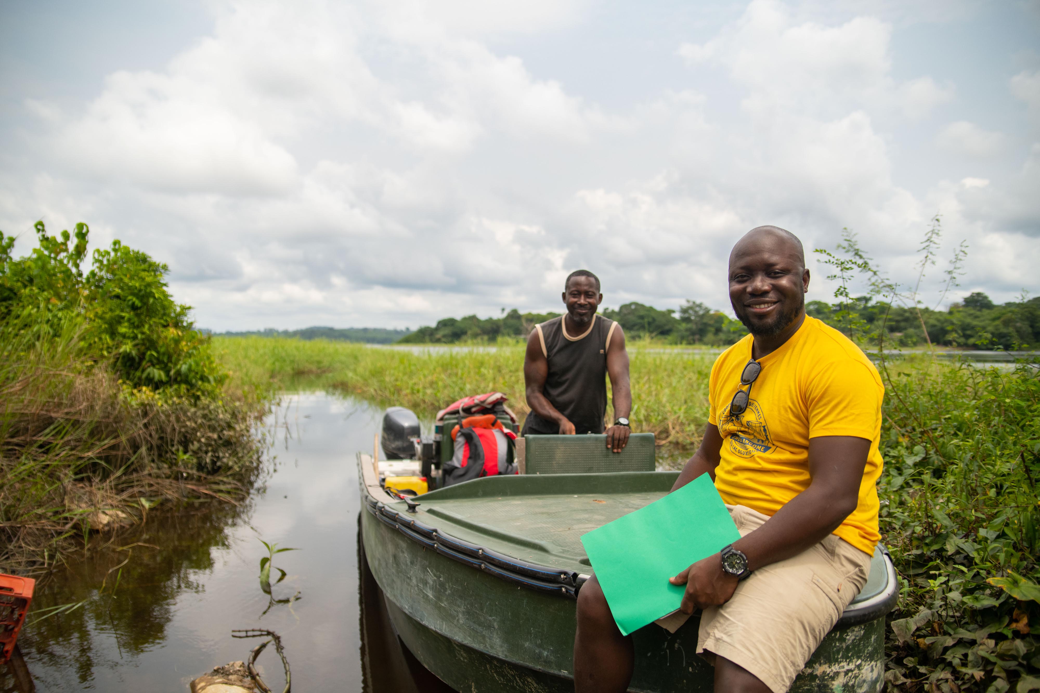 Jean Churley Manfoumbi sits on the bow of a small boat.